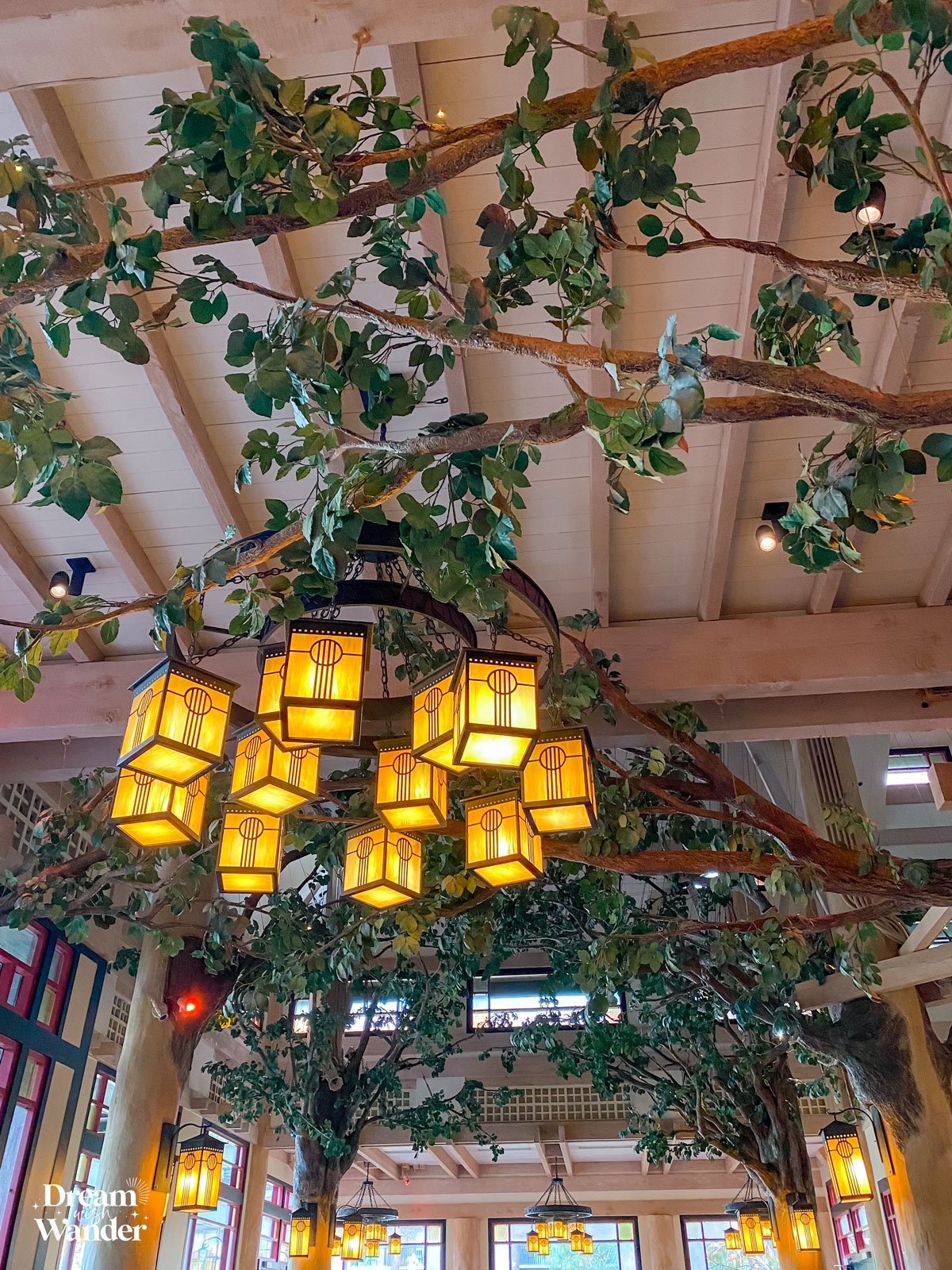 ceiling decor that looks like tree branches and a chandelier that looks like lanterns inside Storybook Dining at Artist Point