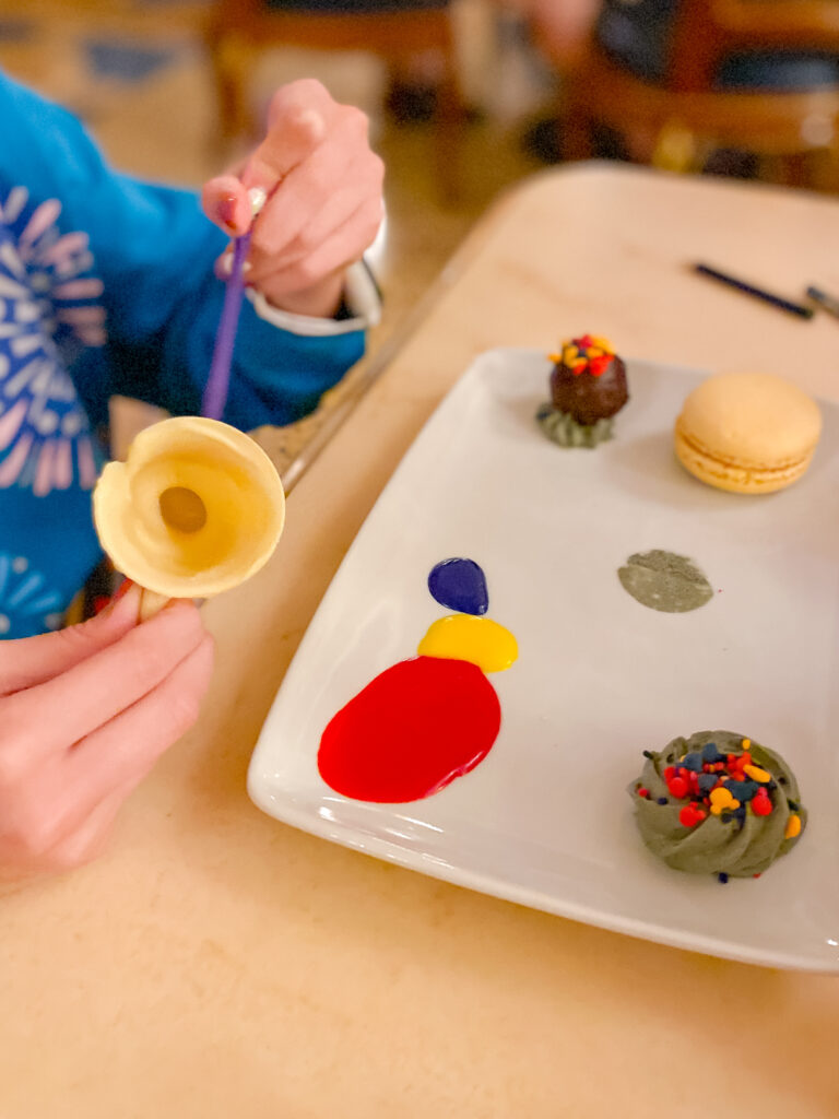 painting the chocolate cup from the kids dessert at Disney Be Our Guest Restaurant Review